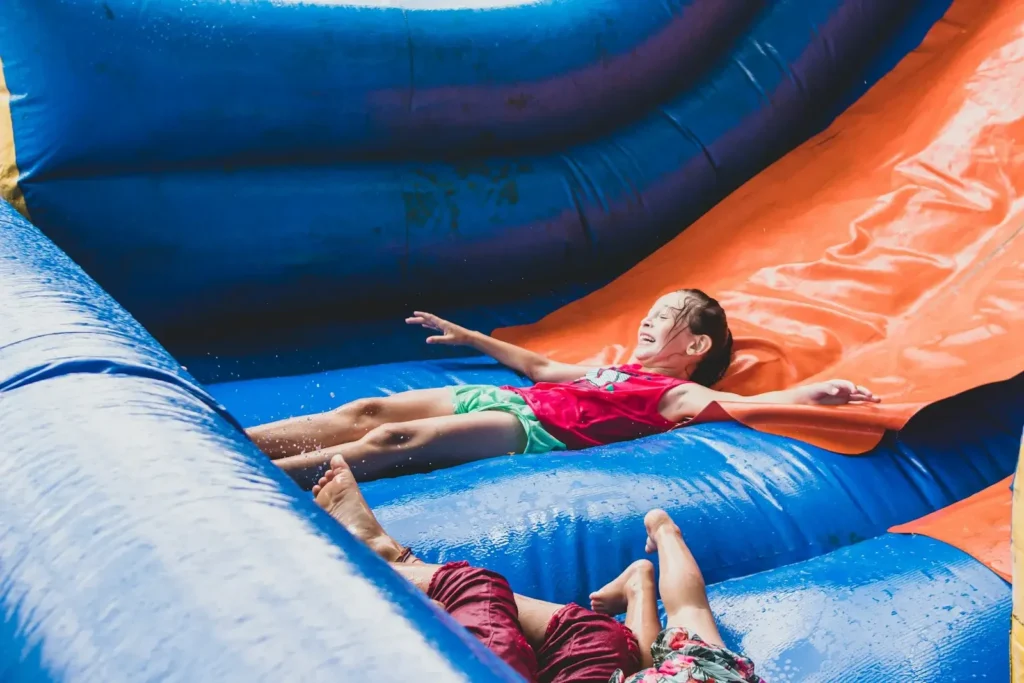 a couple of people laying on top of an inflatable slide