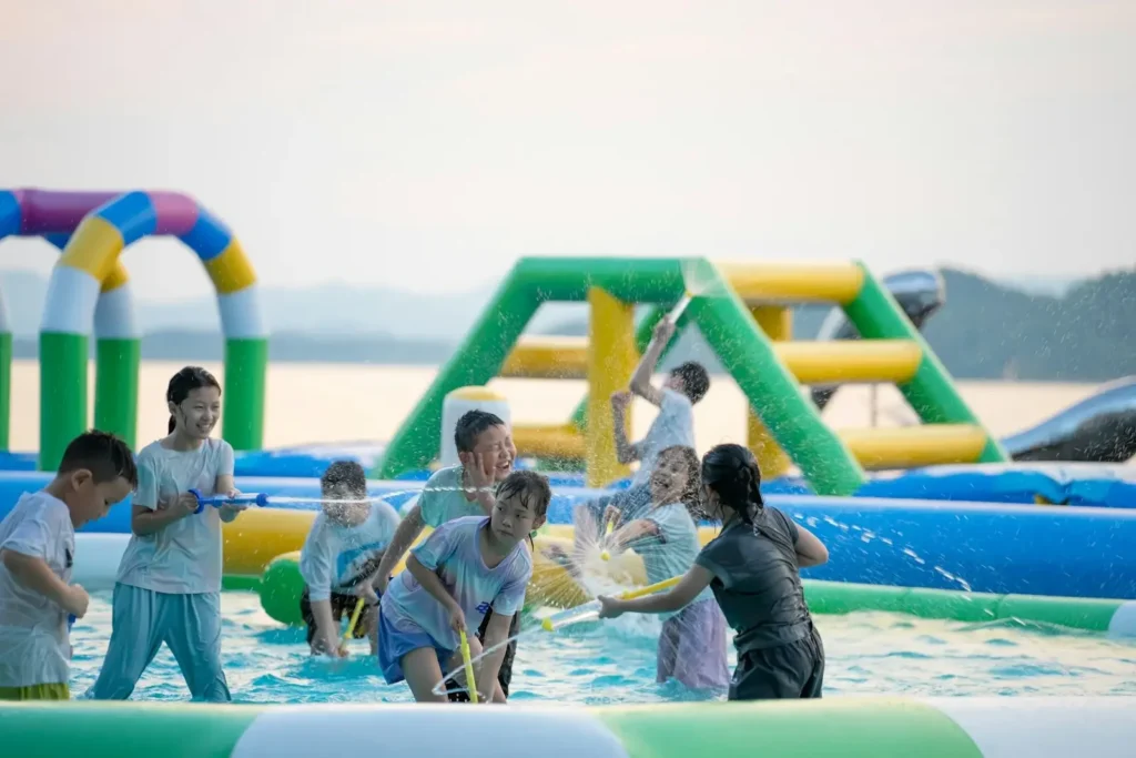 Children playing with water guns at an inflatable water park