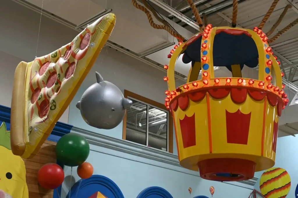 Giant pizza slice, dolphin, and colorful hot air balloon decoration